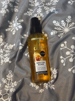 Schwarzkopf Gliss Daily Oil Elixir - Helt oanvänd. Gliss Daily Oil Elixir från Schwarzkopf är en hårolja i en genomskinlig plastflaska med svart pump. Innehåller 75 ml och är framtagen för att reparera och skydda håret mot extrem skada. Oljan har en gyllene färg och ger näring och glans.