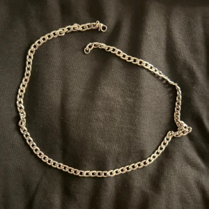 Kedjehalsband i silverfärg - Stilrent halsband med klassisk kedjelänk i silverfärg. Perfekt för dig som gillar en enkel men snygg accessoar som passar till det mesta. Halsbandet har ett smidigt lås och känns både trendigt och tidlöst.