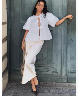 Satin midi skirt, Chapman strl 36 Helt ny! - Snygg champagnefärgad långkjol i satin med mjuk glans och elegant fall. Kjolen har en enkel och stilren design som ger en lyxig känsla. Perfekt att styla med både klackar och sneakers för en trendig look.