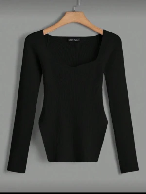  Topp svart - Trendig svart stickad topp från SHEIN med ribbad struktur och fyrkantig urringning. Långärmad modell som sitter figurnära och har en modern, stilren look. Perfekt att matcha med jeans eller kjol för en snygg outfit.