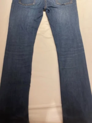 Levi’s mörkblåa jeans - Säljer ett par blå jeans med rak passform och klassisk femficksdesign. Jeansen har en snygg tvättad look och kontrastsömmar. Perfekta till vardagsstilen och funkar året runt. Materialet är denim i bomull.