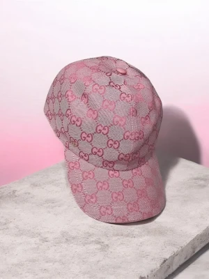 Rosa keps med mönster  - Säljer en snygg rosa keps med det klassiska mönstret över hela kepsen. Kepsen har böjd skärm och är tillverkad i ett tygmaterial som känns lyxigt och trendigt. Perfekt accessoar för att lyfta din outfit.