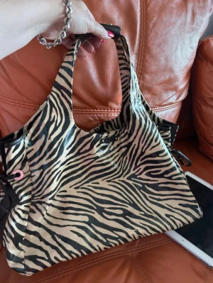 Kate spade väska Zebramönstrad  - En av mina favvo väskor någonsin men tyvärr har jag tröttnat nu, väl använd! Slitningar vid handtaget och snörena, annars fin påse på insidan och utsidan!