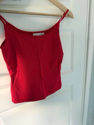  Red Winter Cami Top – Soft & Stylish - ❤️ Red Winter Cami Top – Soft & Stylish ❤️  Cute red spaghetti strap top, perfect for layering during winter ❄️ Wear it with a cozy cardigan, oversized blazer, jeans, or leather pants for a trendy winter look. Soft, stretchy, and comfortable material. Great for casual outfits, parties, dates, or holiday season styling.  ✨ Condition: Good ✨ Color: Bright red ✨ Style: Minimalist / basic / Y2K inspired ✨ Easy to match with winter outfits 