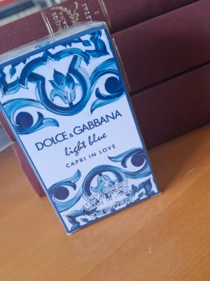 Dolce & Gabbana Light Blue Capri - Den är helt ny, förpackad. Dolce & Gabbana Light Blue Capri In Love pour homme är en parfym i en snyggt dekorerad kartong med blå och vita mönster. Eau de parfum, 50 ml, med italiensk inspiration och exklusiv känsla. Perfekt för dig som gillar fräscha och eleganta dofter. 
