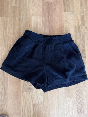 Svarta frottéshorts från 157, XS - Mysiga svarta shorts från 157 i frotté med elastisk midja och två fickor. Perfekta för chill dagar eller när du vill ha något bekvämt och enkelt. Klassisk modell med loose fit och mjukt material.