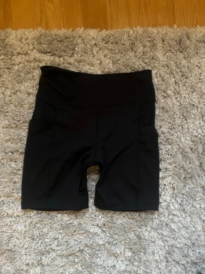 Träningsshorts - Svarta träningsshorts från Relode med bred resår i midjan och praktiska sidofickor. Shortsen har en snörning runt midjan ifall man skulle vilja dra åt dem men det är ganska tighta. Endast testade!💞💞