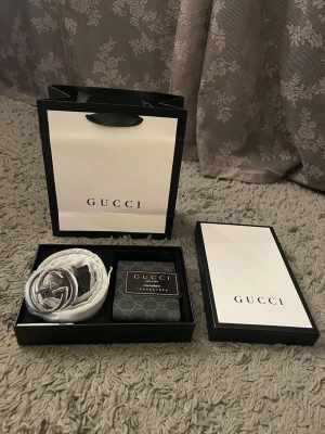 Svart Gucci bälte med plånbok - Snyggt svart bälte från Gucci med ikoniskt GG-spänne i silver. Bältet och plånboken är heller nya 
