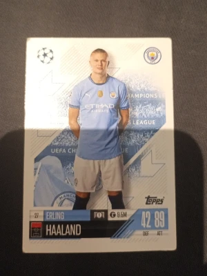 Topps fotbollskort Erling Haaland - Samlarfotbollskort från Topps med Erling Haaland i Manchester Citys blå matchtröja. Kortet har detaljer som spelarens namn, klubbmärke och statistik. Perfekt för dig som gillar fotboll och samlarkort.