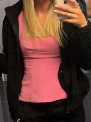 Zara topp - Snygg rosa linnetopp med figurnära passform och fyrkantig ringning. Perfekt att styla med jeans eller kjol för en trendig look. Enkel och stilren design utan synliga detaljer.
