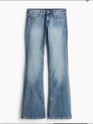 SLUTSÅLDA Low waits jeans från HM - Snygga blå bootcut jeans med ljus tvätt och klassisk femficksdesign. Jeansen har normal midja och subtila slitningar framtill för en trendig look. Perfekta för dig som gillar en avslappnad men ändå stilren vibe.