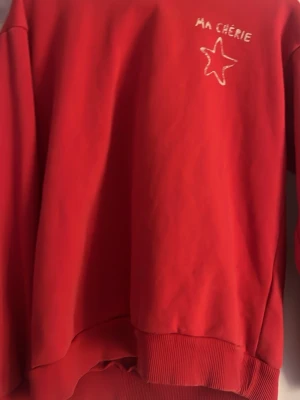 Ma chérie tröja - Röd hoodie med huva och trycket 'MA CHÉRIE' samt en stjärna både fram och bak.