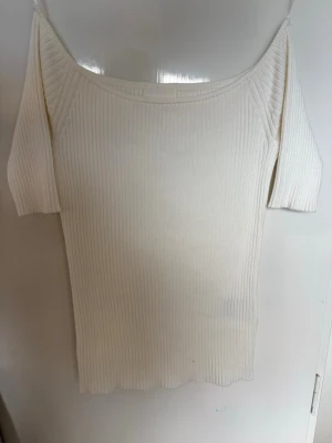 Vit ribbad offshoulder topp - Snygg vit ribbad topp med offshoulder-design och korta ärmar. Mjuk och stretchig känsla som sitter skönt på kroppen. Aldrig använt helt ny.          ‼️pris kan diskuteras ‼️ 