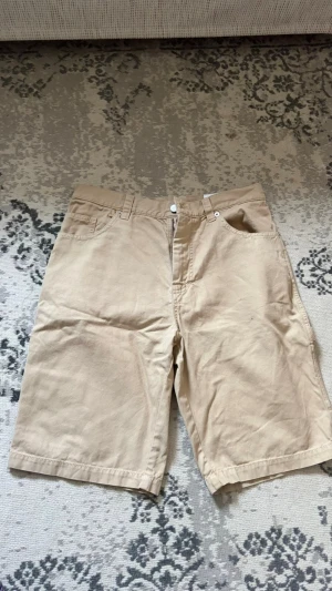 Axel arigato cargo shorts - Helt nya och oanvända cargoshorts från Axel Arigato i en snygg beige färg. Prislapp och lädertag sitter kvar. Broderad logga på sidofickan. Perfekt passform för sommaren.  Storlek M
