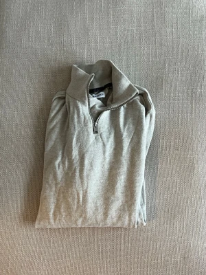 Beige stickad tröja halv-zip tröja - Snygg beige stickad tröja i storlek M från Jack & Jones med halv dragkedja och hög krage. 