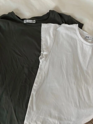 Två basic t-shirts från Zara - Säljer två enkla t-shirts från Zara, en i svart och en i vitt. Båda har rund halsringning och korta ärmar. Perfekta att matcha till jeans eller shorts för en clean och avslappnad look.
