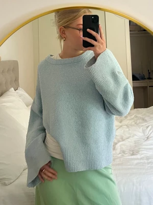 Ljusblå stickad tröja - Mysig ljusblå stickad tröja med oversized passform och breda ärmar. Tröjan har rund halsringning och ribbade muddar vid ärmslut och nederkant. Perfekt för lager på lager och en chill look. Pris kan alltid diskuteras 🥰några fläckar finns längst ner på tröjan samt vid handleden (bild 6&7)💕