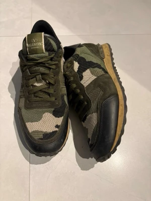Valentino camo sneakers - Säljer nu ett par snygga Valentino Rockrunners som är använda ett fåtal par gånger, har ingen användning utav dem. Skriv vid förhandling om pris!