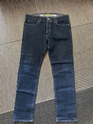 Mörkblå Lee Extreme Motion jeans - Säljer ett par mörkblå Lee Extreme Motion jeans med slim fit och avsmalnande ben. Klassisk femficksmodell med stretchigt material för extra komfort. Perfekta för dig som vill ha både stil och rörelsefrihet.