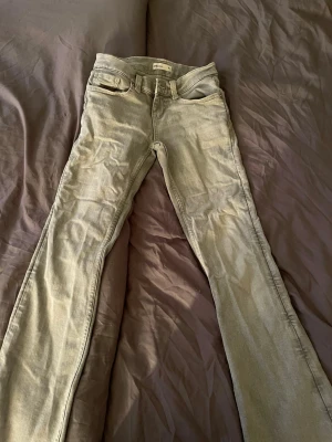 Ljusgrå bootcut jeans från Gina Tricot - Säljer ett par ljusgrå jeans från Gina Tricot med bootcut-modell. I storlek 34 dom har en lite fläck på benet men inget man märker har använt 2 gånger 