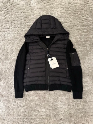 Moncler Cardigan Äkta - Svart Moncler Cardigan, helt ny. Finns inga fel. Äkta kvitto finns digitalt. Köpt direkt från Monclers hemsida för cirka 13 280. Använt en gång. Alla original etiketter finns med. Inga fel överhuvudtaget. Pris kan förhandlas lite vid snabb affär. Skickas samma dag. Mer bilder kan fixas för seriösa köpare.
