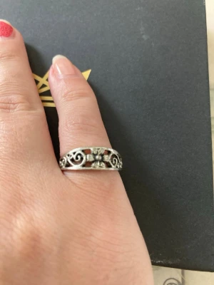 Silverring med blommönster - Snygg silverfärgad ring med detaljerat blommönster och snirkliga inslag runt hela ringen. Ringen har en klassisk, bohemisk känsla och passar perfekt för dig som gillar unika accessoarer. Materialet ser ut att vara metall i silverton.