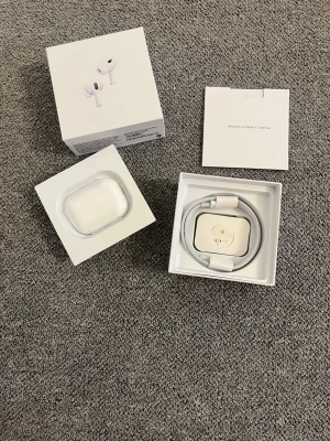 Apple AirPods gen 2 PRO - Säljer ett par vita Apple AirPods Pro med trådlöst laddningsetui. Hörlurarna har en stilren och kompakt design i blank plast och levereras i originalförpackning med laddkabel och manual. Perfekta för dig som vill ha grymt ljud och smidig anslutning till iPhone.