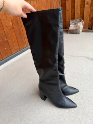 Svarta höga stövlar med klack - Säljer ett par svarta höga stövlar med spetsig tå och bred klack. Har aldrig använt. 