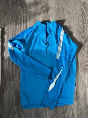 🔵⚽️NIKE DRI-FIT TRÄNINGSTRÖJA – STRL S ⚽️🔵 - 🏃‍♂️ Säljer en snygg och funktionell Nike Dri-FIT långärmad träningströja i storlek S.  🔹 Klarblå färg med vita detaljer på ärmarna 🔹 Dri-FIT-material som transporterar bort fukt och håller dig torr under träning 🔹 Kort dragkedja framtill 🔹 Perfekt för gym, löpning, fotboll eller annan träning 🔹 Bekväm passform och lätt material.                   💬 Hör gärna av dig vid frågor eller om du vill ha fler bilder!