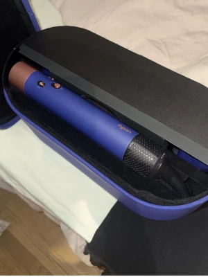 Dyson Airwrap Complete blå/koppar. - Säljer ett komplett Dyson Airwrap stylingkit i blått med flera utbytbara borsthuvuden och tillbehör. Allt kommer i ett matchande blått fodral. Perfekt för att styla håret med olika borstar och locktillbehör. Snygg design med detaljer i roséguld. Fick i present, används aldrig så den är som ny! Pris kan diskuteras. (Skickar fler bilder i chatten om önskas.