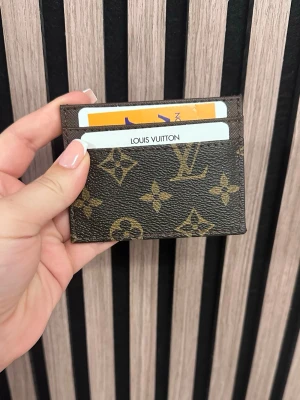  monogram kortfodral - . Tillverkat i tåligt canvasmaterial med plats för flera kort. Slimmad och smidig design som passar perfekt i fickan. 
