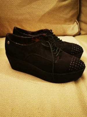 Studded Platform Oxfords – Size 39 - Säljer ett par svarta platåskor i mockaliknande material med snörning och silvriga nitar framtill på tån. Skorna har chunky platåsula och insidan är fodrad med leopardmönster. Perfekt för dig som gillar edgy och unik stil.