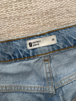 Ljusblå jeans från ginatrico perfect jeans - Säljer ett par ljusblå jeans från ginatrico perfect jeans i storlek 38. Klassisk femficksmodell med raka ben och slitstark denim. Perfekta till en avslappnad look och passar till det mesta. Snygga kontrastsömmar och tidlös design.