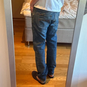 Blå nudie jeans  - Storlek: W31 L34. Midjemått tvärs över: 44cm upplevs större än W31 enligt mig. Modell: Gritty Jackson. Bra skick - lite heelbite se sista bilden 