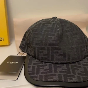 Svart Fendi keps med FF-mönster - Snygg svart keps från Fendi med det klassiska FF-logomönstret över hela kepsen. Kepsen har böjd skärm och justerbar rem bak. Tillverkad i ett slitstarkt tygmaterial som ger en exklusiv känsla. Perfekt accessoar för dig som gillar lyxiga detaljer.