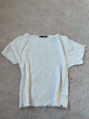 Vit topp från LAGER 157 - Säljer en vit topp med fint mönster. Materialet är mjukt och stretchigt, lätt att även matcha med olika outfits. Använd typ 2 gånger. 