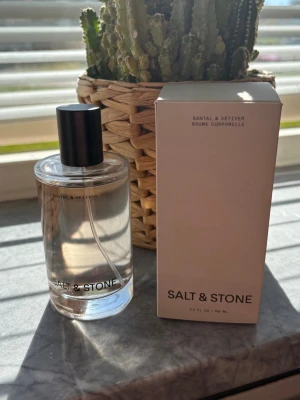 Salt & Stone Santal & Vetiver parfym - Salt & Stone Santal & Vetiver parfym med transparent glasflaska och svart cylinderformad kork. Doften har en modern och minimalistisk design, och medföljande ljusbeige kartong. Perfekt för dig som gillar fräscha och träiga toner. Endast testad 