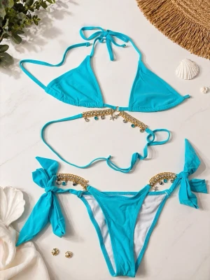 Turkos bikini med gulddetaljer och knyt - Snygg turkos bikini med trekantsöverdel och knyt i nacken och ryggen. Underdelen har stora rosetter på sidorna och båda delarna är dekorerade med guldfärgade pärlor och små berlocker. Perfekt för stranden eller poolen!
