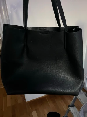Svart handväska från H&M - Säljer en svart, fin handväska från H&M. Nypris 450kr.