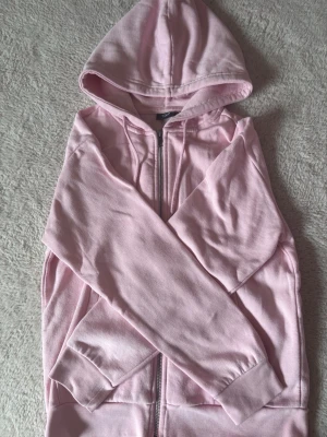 Ljusrosa ziphoodie - Ljusrosa ziphoodie från lager 157 med dragkedja framtill, huva med snören och två stora fickor. Mjuk bomullskänsla och ribbade muddar vid ärmslut och nederkant. Perfekt för en avslappnad och chill look. Fortfarande ganska mjuk på insidan har haft länge men knappt använd