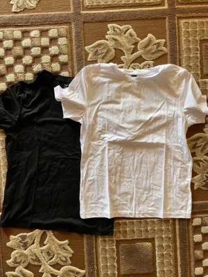 Svart och vit basic t-shirt - Två klassiska t-shirts i svart och vitt, perfekt för dig som gillar enkel och stilren look. Båda har rund hals och korta ärmar, tillverkade i mjukt bomullsmaterial som är skönt mot huden. Passar till jeans eller shorts och är ett måste i garderoben.