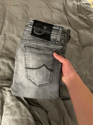 Grå  jeans från Jacob Cohen - Snygga grå jeans från Jacob Cohen med klassisk femficksdesign och svart patch med logga bak. Jeansen har en tvättad look, Perfekta för en trendig och avslappnad stil. 688
