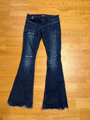 Mörkblå bootcut jeans med slitningar från GinaYoung - Mörkblåa lågmidjade bootcut jeans med slitningar från GinaYoung i storlek S + långa bordellen, har dock klippt av mina men finns fortfarande längd, jag är 156cm. 