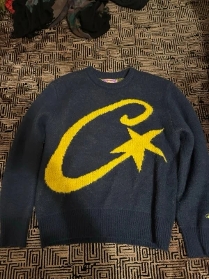 Mörkblå stickad tröja från corteiz - Mörkblå stickad tröja från NS med enkel design och ribbstickade muddar vid ärmslut och nederkant. Tröjan är långärmad och har en klassisk rund halsringning. Perfekt för att hålla värmen under kyliga dagar.