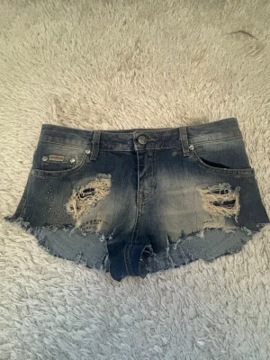 Blå slitna jeansshorts med fransar - Lågmidjade  blå jeans shorts