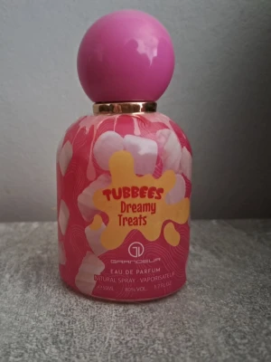 Tubbees Dreamy Treats parfym 50ml - Tubbees Dreamy Treats Eau de Parfum från Grandeur. Flaskan är rosa med vita och gula detaljer och har en rund, rosa kork. Söt och lekfull design som sticker ut på parfymhyllan. Innehåller 50 ml och har en färgglad, ungdomlig look.