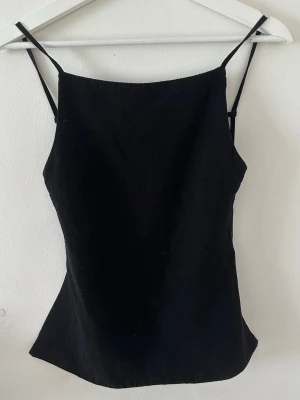 Svart topp - Jättesnygg topp med öppen rygg! Banden går att spänna, använd få gånger