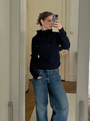 Svart hoodie med huva - Säljer en svart hoodie med halvhuva i storlek s/xs från H&M. Hoodien har en avslappnad passform och långa ärmar. Perfekt till jeans eller mjukisbyxor för en chill look.