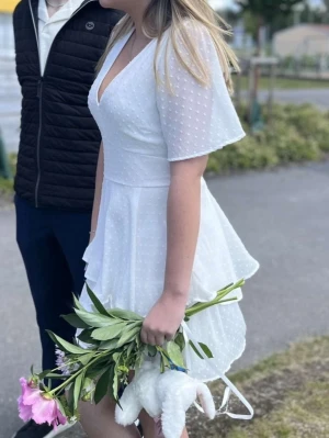 Vit kort omlottklänning med volang - Säljer min avslutningsklänning från 9an. Superfint skick och endast använd en gång på avslutningen. Storlek 36❤️
