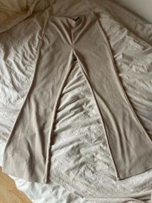  Beige bootcut byxor  - Säljer dessa byxorna då de inte faller mig i smaken längre. Använt de väldigt sällan, men har tyvärr råkat riva dem lite på framsidan (bild 3&4), men inget som syns tydligt😙